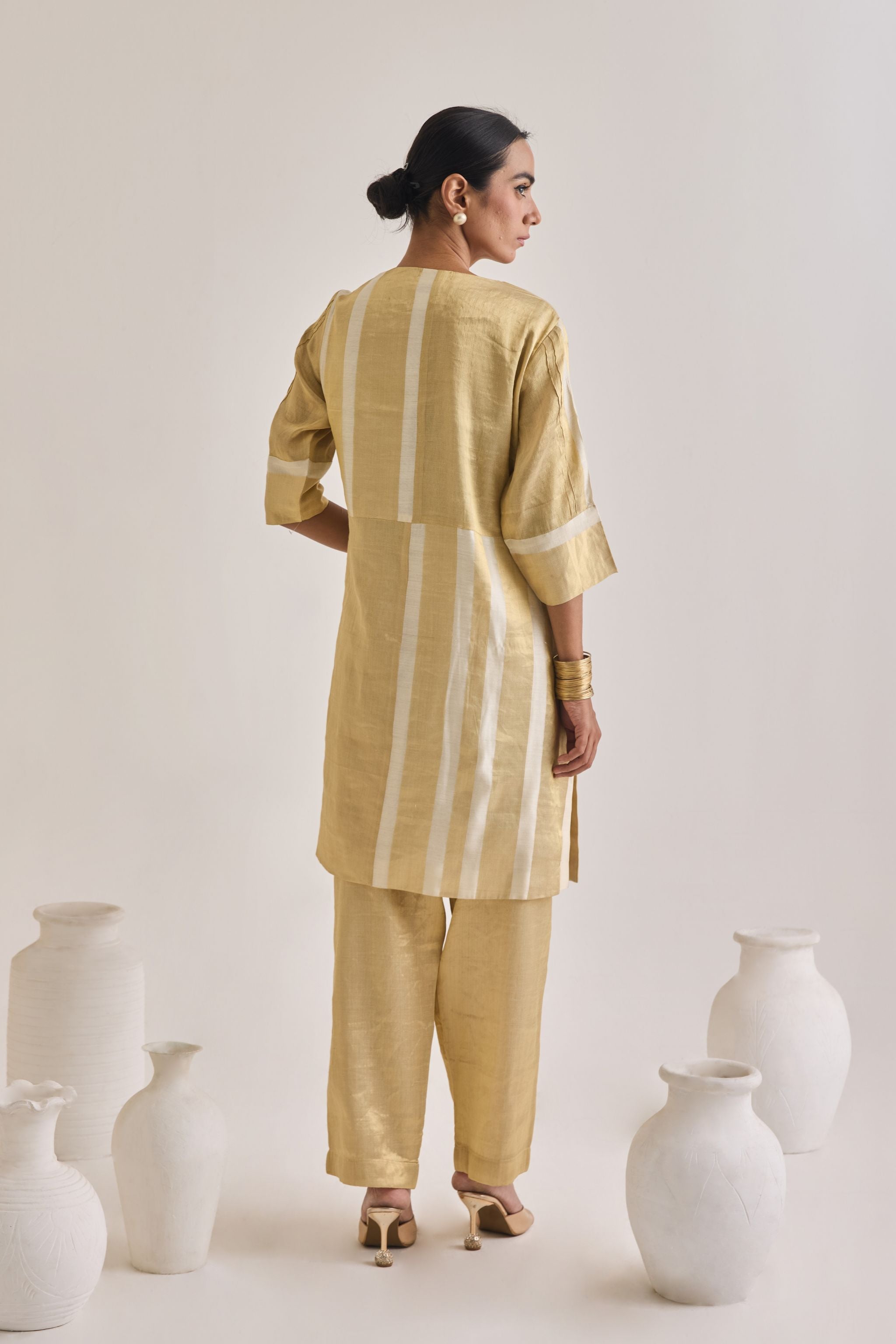 Back view of golden Banarsi co-ord set made using pure banarsi fabric with a blocked design on Kurta and pants