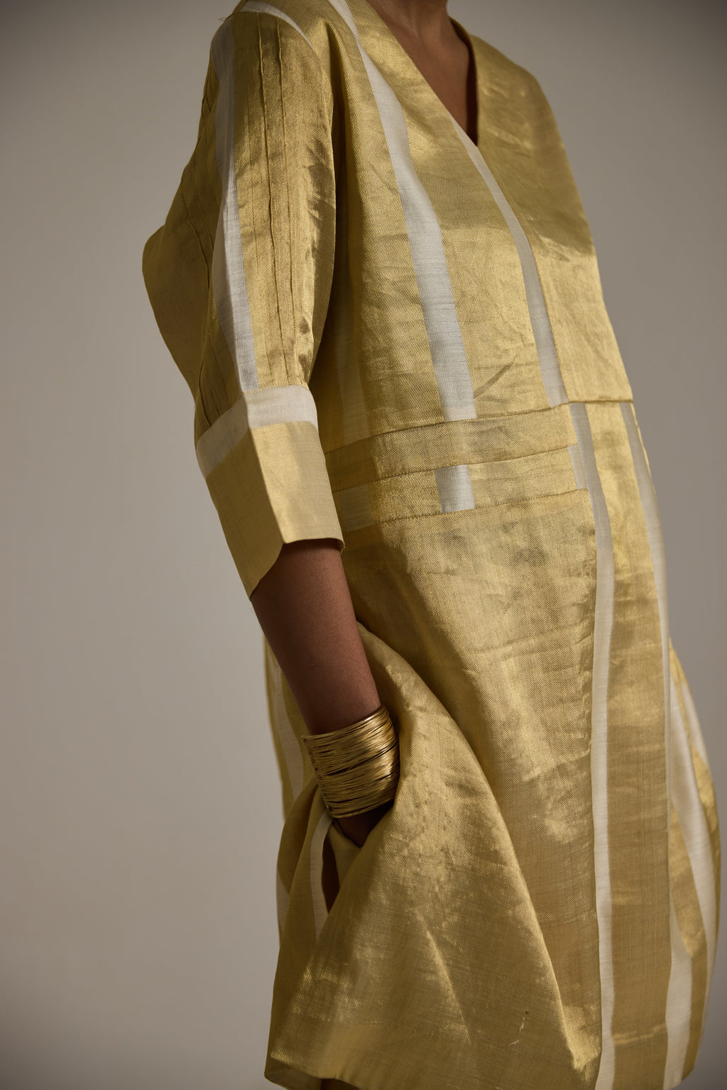 Close up view of Golden banarsi kurta with 3/4th sleeves and pin tuck detail and pants with pockets