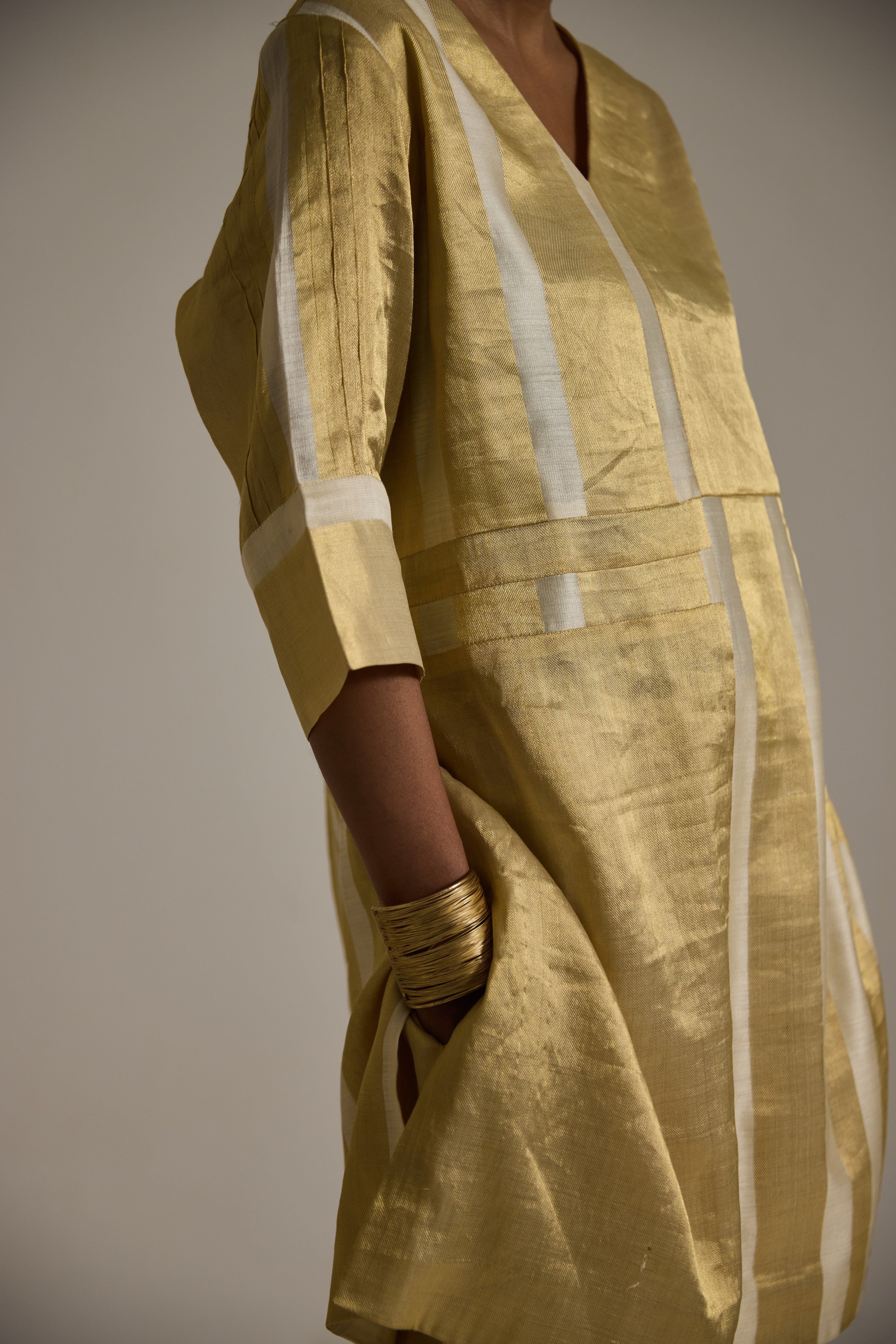 Close up view of Golden banarsi kurta with 3/4th sleeves and pin tuck detail and pants with pockets