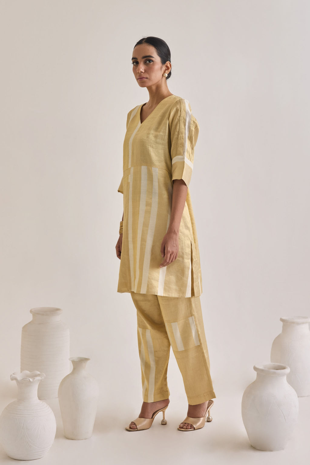 Side view of golden Banarsi co-ord set made using pure banarsi fabric with a blocked design on Kurta and pants