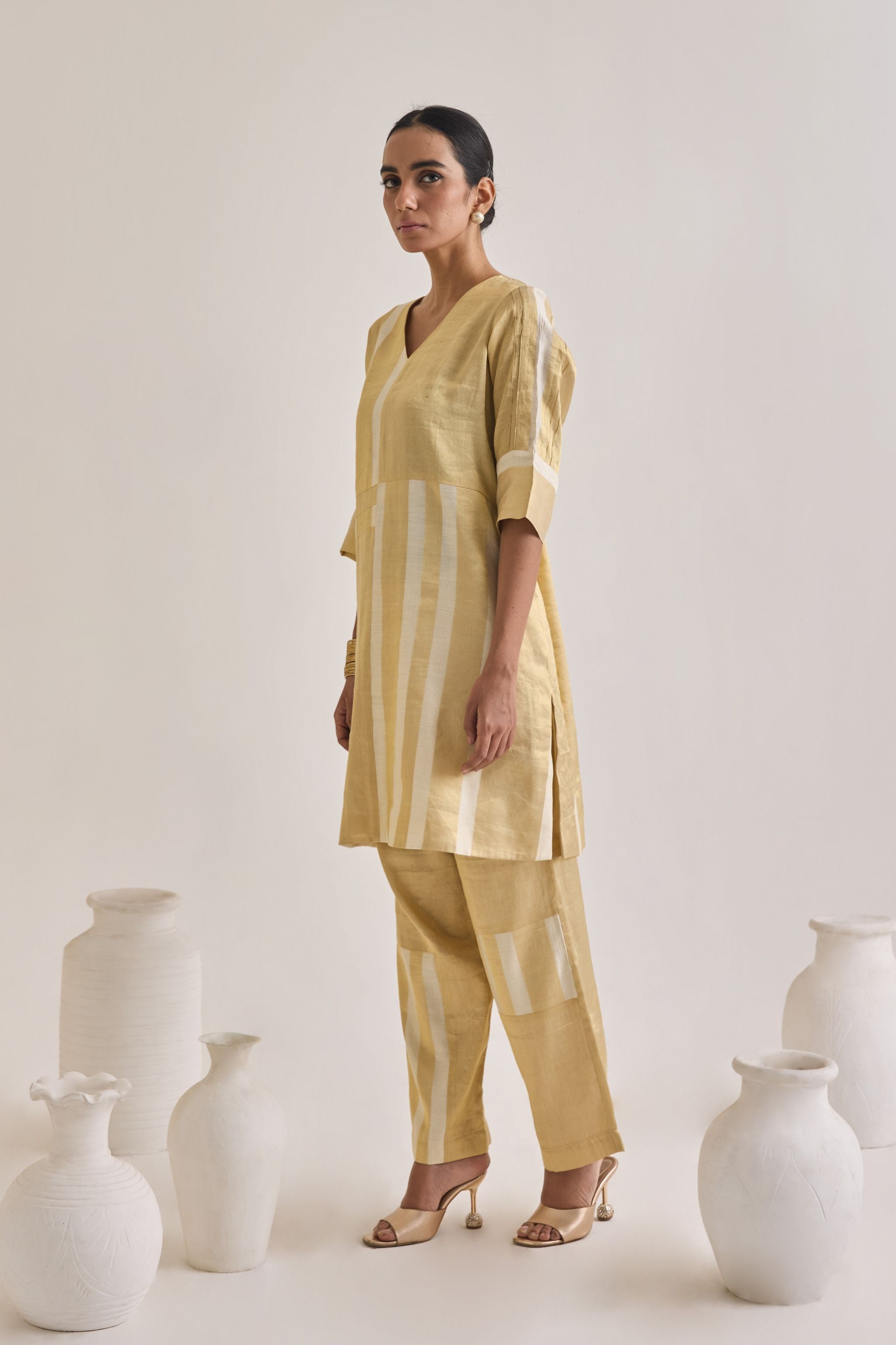 Side view of golden Banarsi co-ord set made using pure banarsi fabric with a blocked design on Kurta and pants