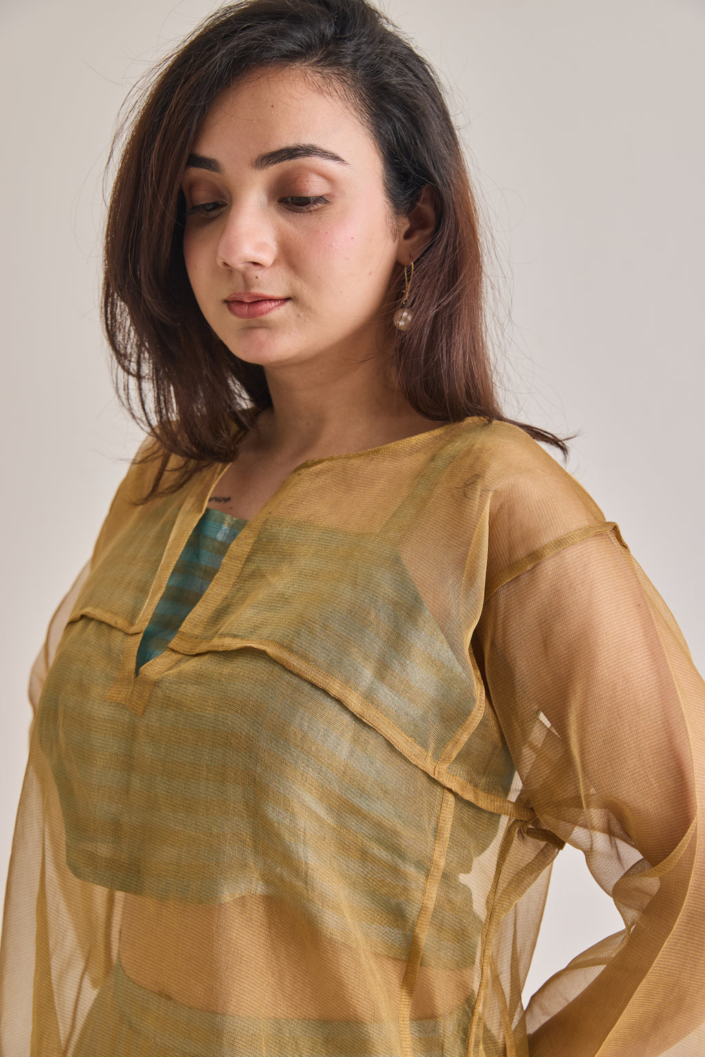 Front close up view of a banarsi teal and golden baggy and oversized 3 piece co-ord set with golden baggy fit kurta and striped slip