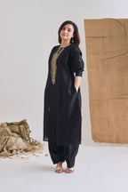 Side view of Black Chanderi long paneled kurta with side pockets and raw jute embroidery on neckline and salwar bottoms