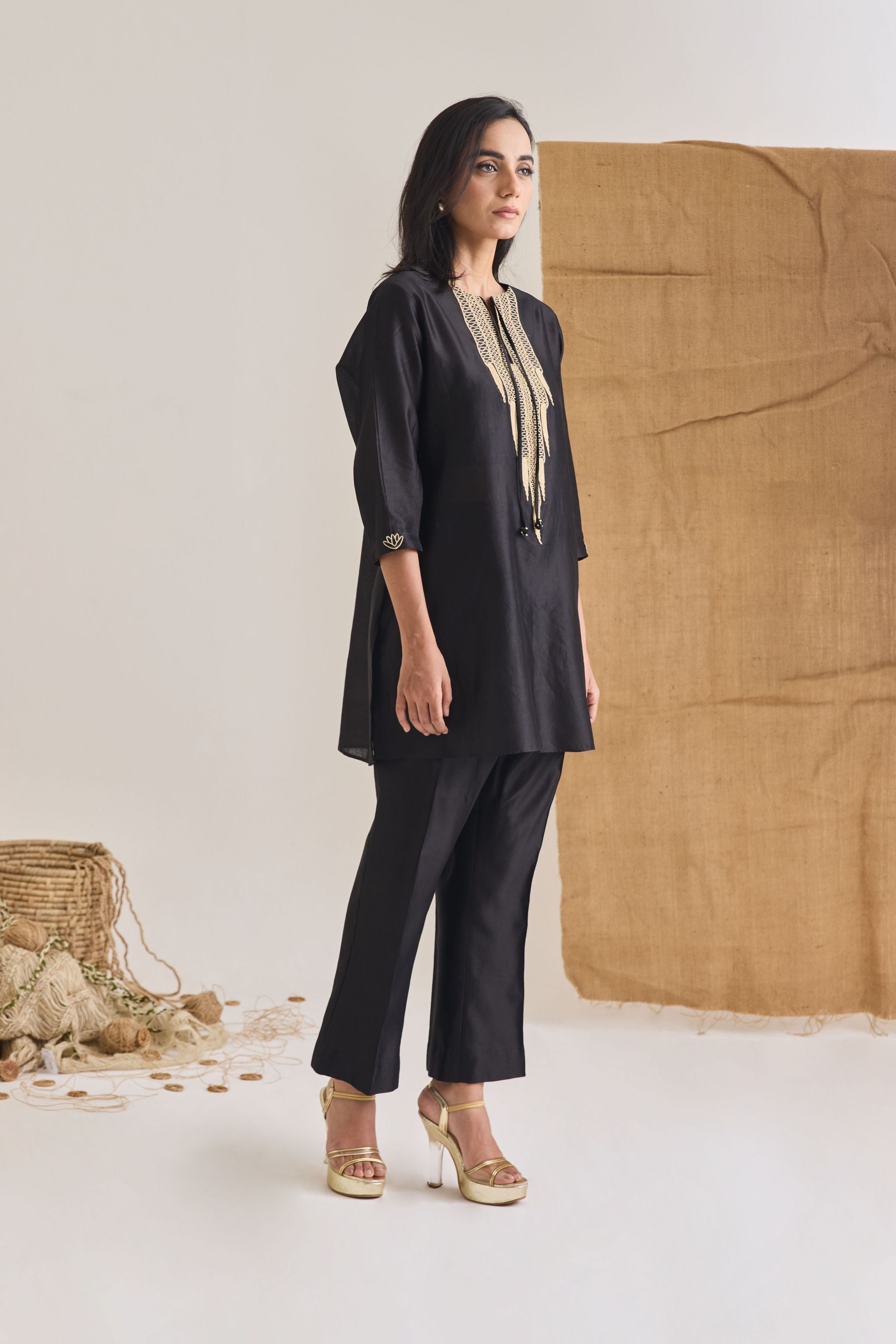 Side view of Black Chanderi short kurta with 3/4th sleeve and raw jute embroidery on neckline and front tie doris
