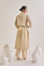 Back view of Chanderi set with a Long coat having notched collar and a back knot design, Fringed stripes  Kurta and crease pants