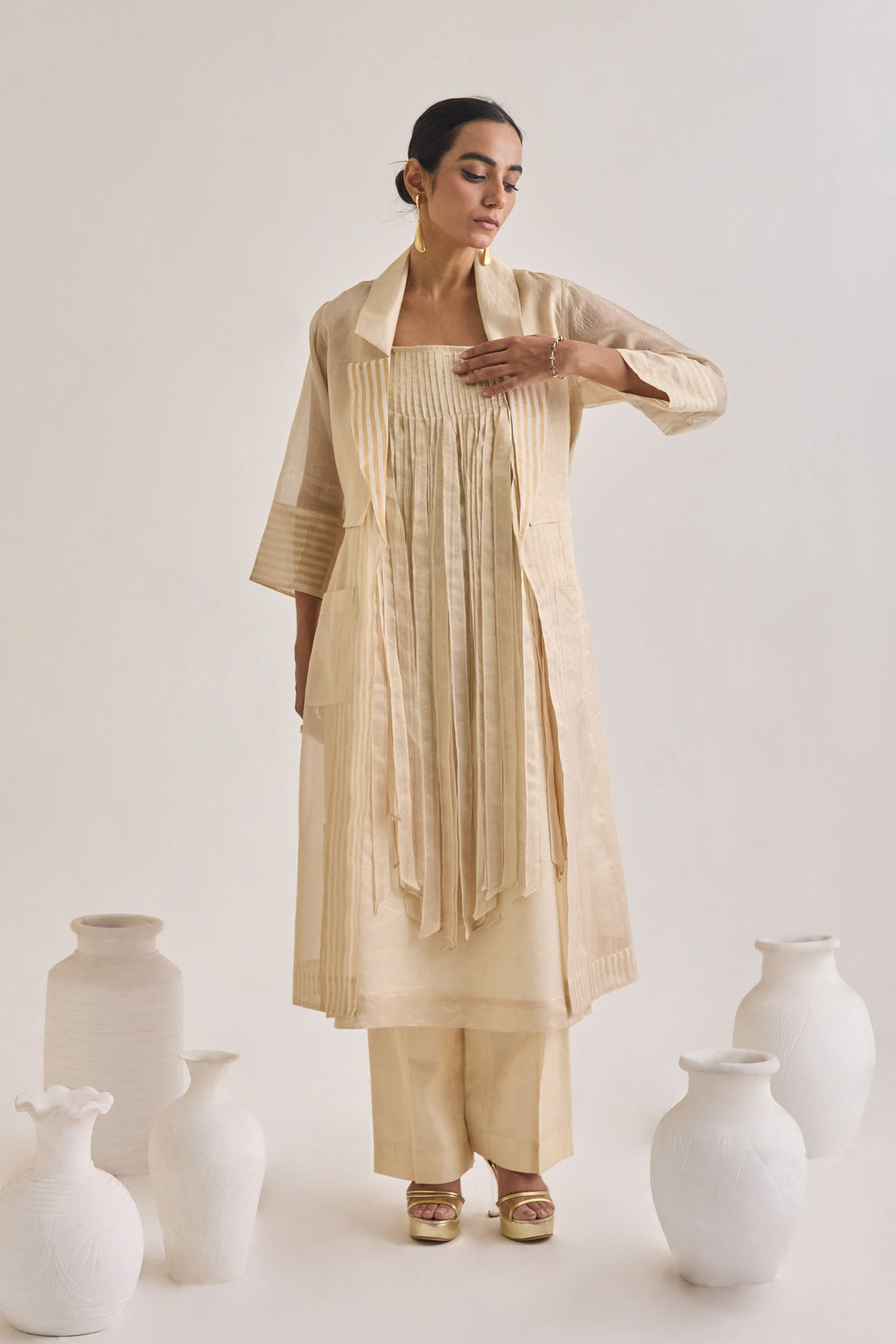 Front view of Chanderi set with a Long coat having notched collar, Fringed stripes Kurta and crease pants