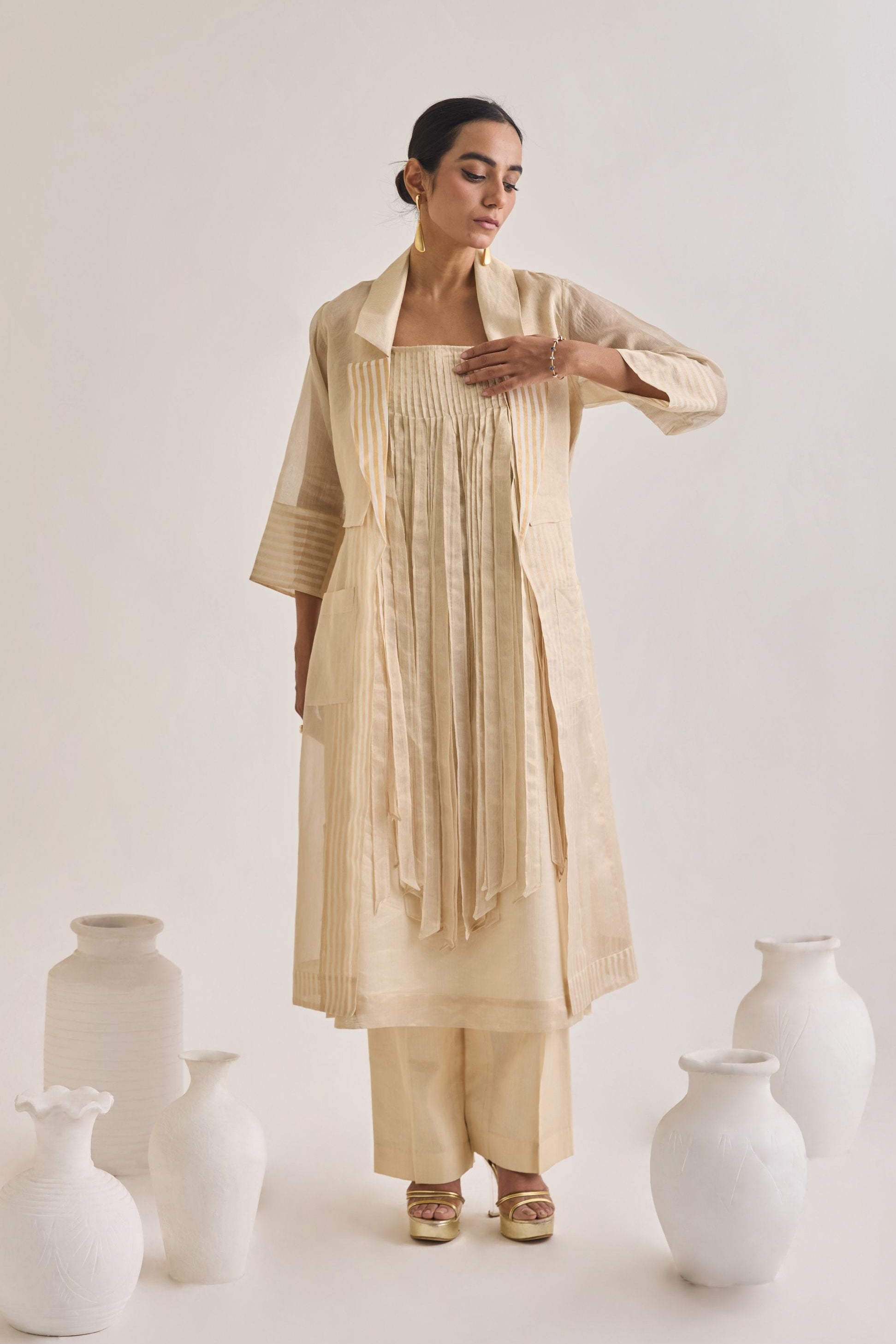 Front view of Chanderi set with a Long coat having notched collar, Fringed stripes Kurta and crease pants