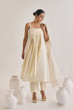 Front view shot of a off white Cotton fringed set with a sleeveless cotton Kurta having Front fringes and crease pants.