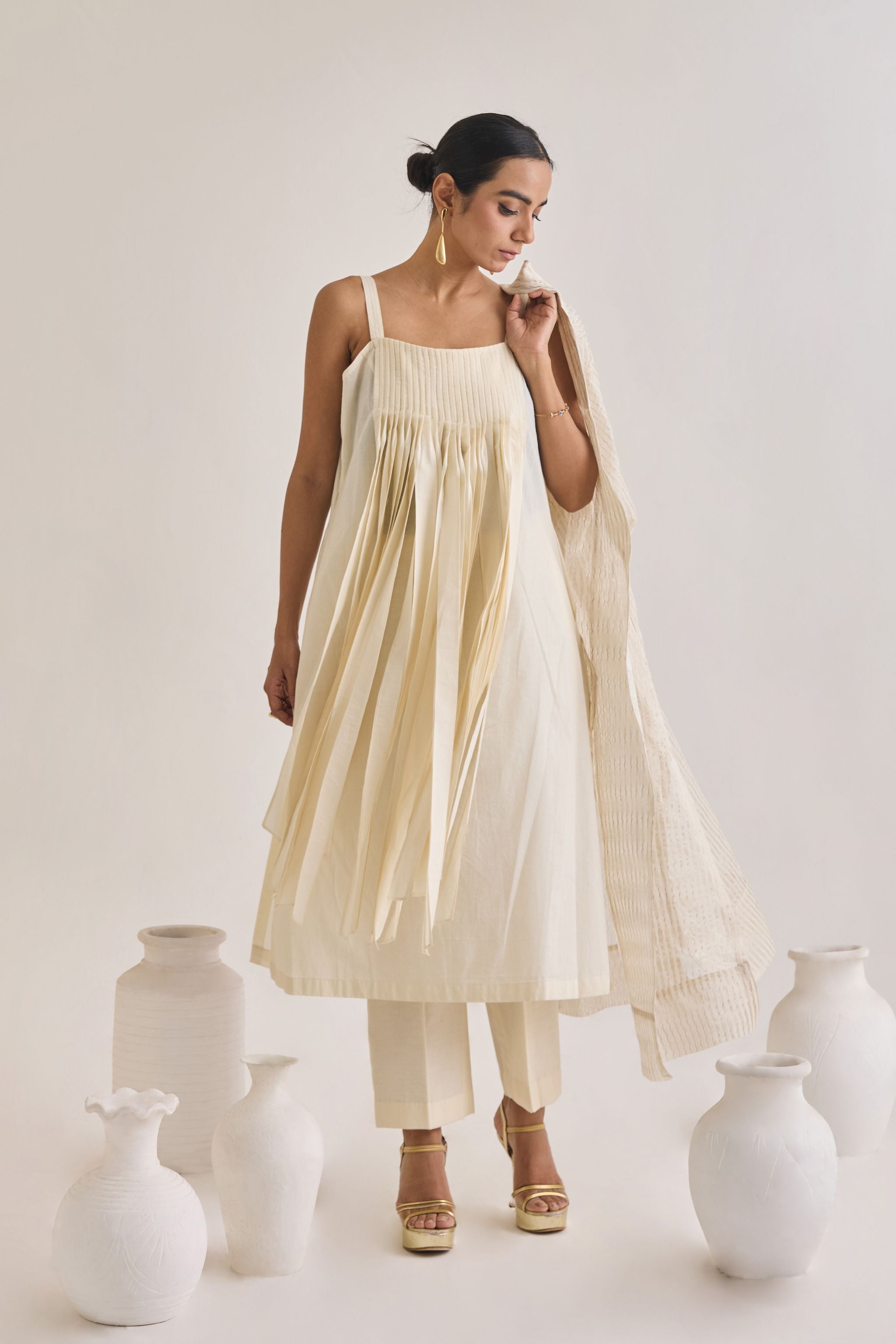 Front view shot of a off white Cotton fringed set with a sleeveless cotton Kurta having Front fringes and crease pants.
