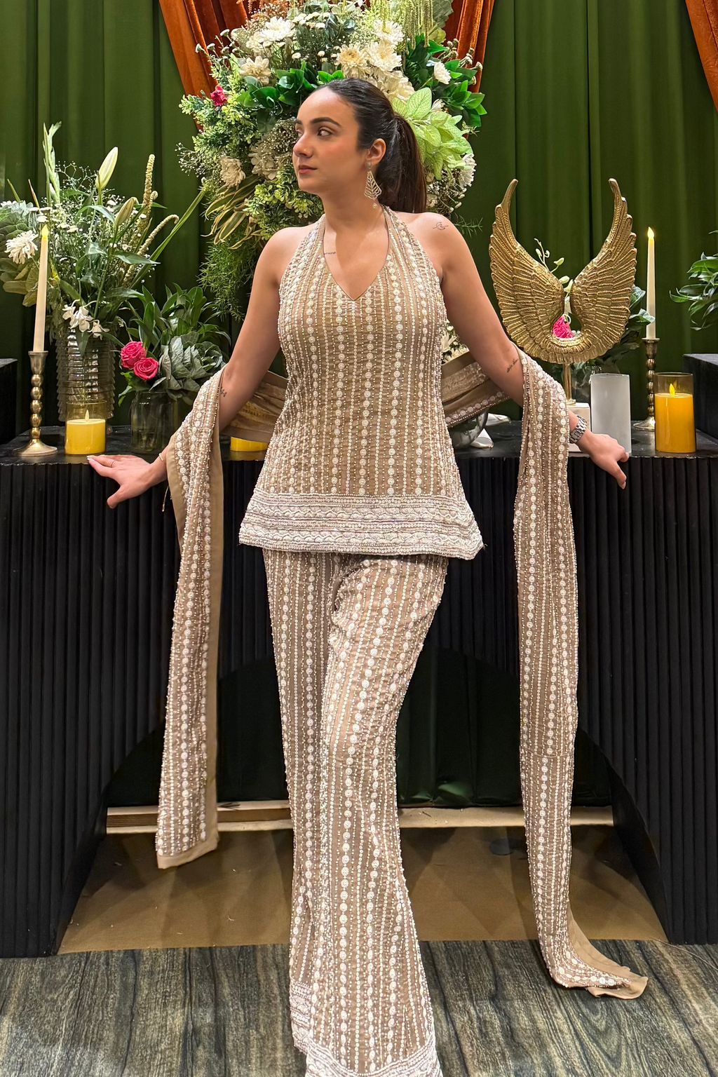 Model in beige embellished halter top and flared bell bottoms, looking to the left | Essence by Monika