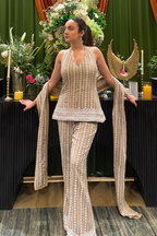 Model in beige embellished halter top and flared bell bottoms, looking to the left | Essence by Monika