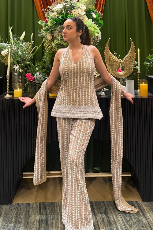 Model in beige embellished halter top and flared bell bottoms, looking to the left | Essence by Monika