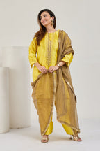 Model in bright yellow Katan silk kurta and farshi salwar with golden Kiran-edged dupatta, looking to the left