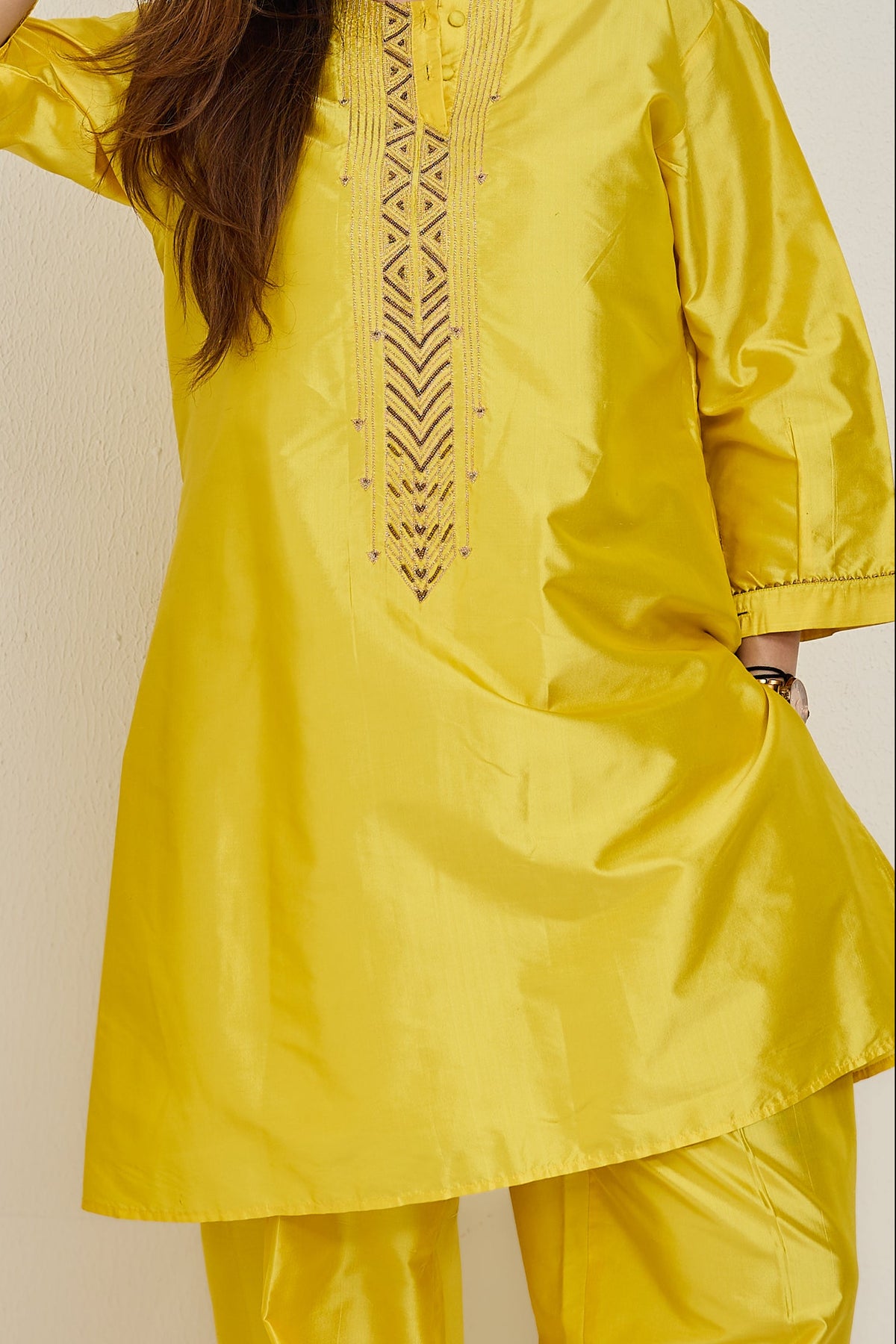 Model in bright yellow A-line Katan silk kurta with lace-edged cuffs and farshi salwar, without dupatta