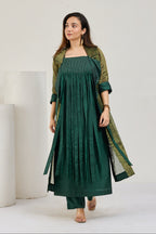 Model in dark green silk strappy kurta with the fringed hem flaring out, front view