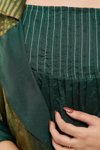 Close-up of pure silk fringes at the hem of a dark green silk kurta