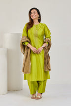 Model in lime green Katan silk kurta set with golden Kiran-edged tissue dupatta, looking to the left