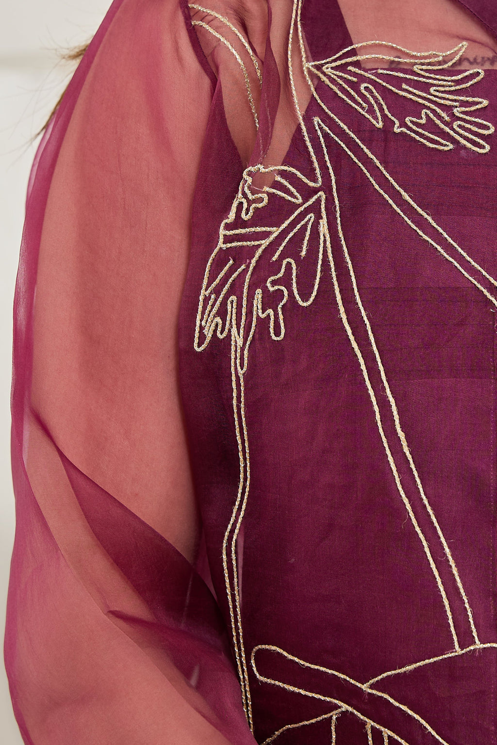 Close-up of hand jute and zari embroidery with seed beads on a wine organza jacket