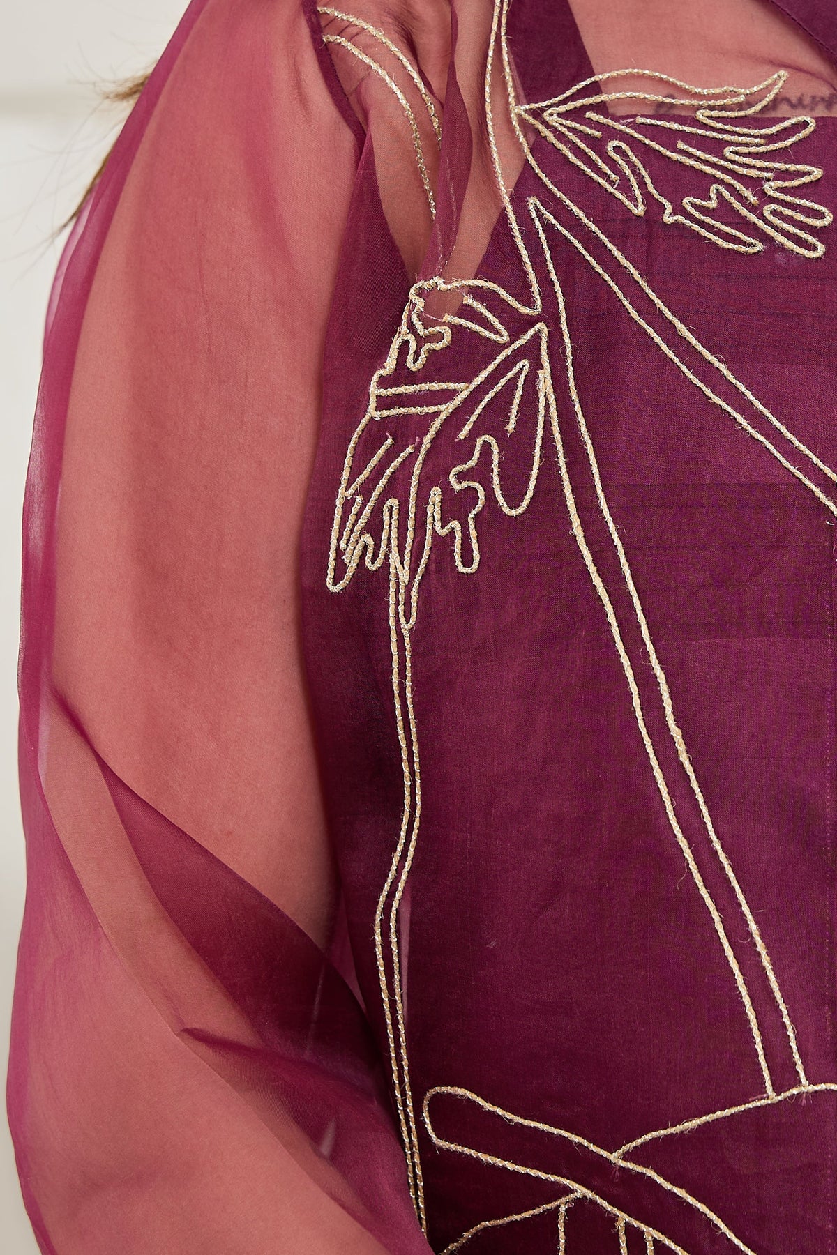 Close-up of hand jute and zari embroidery with seed beads on a wine organza jacket