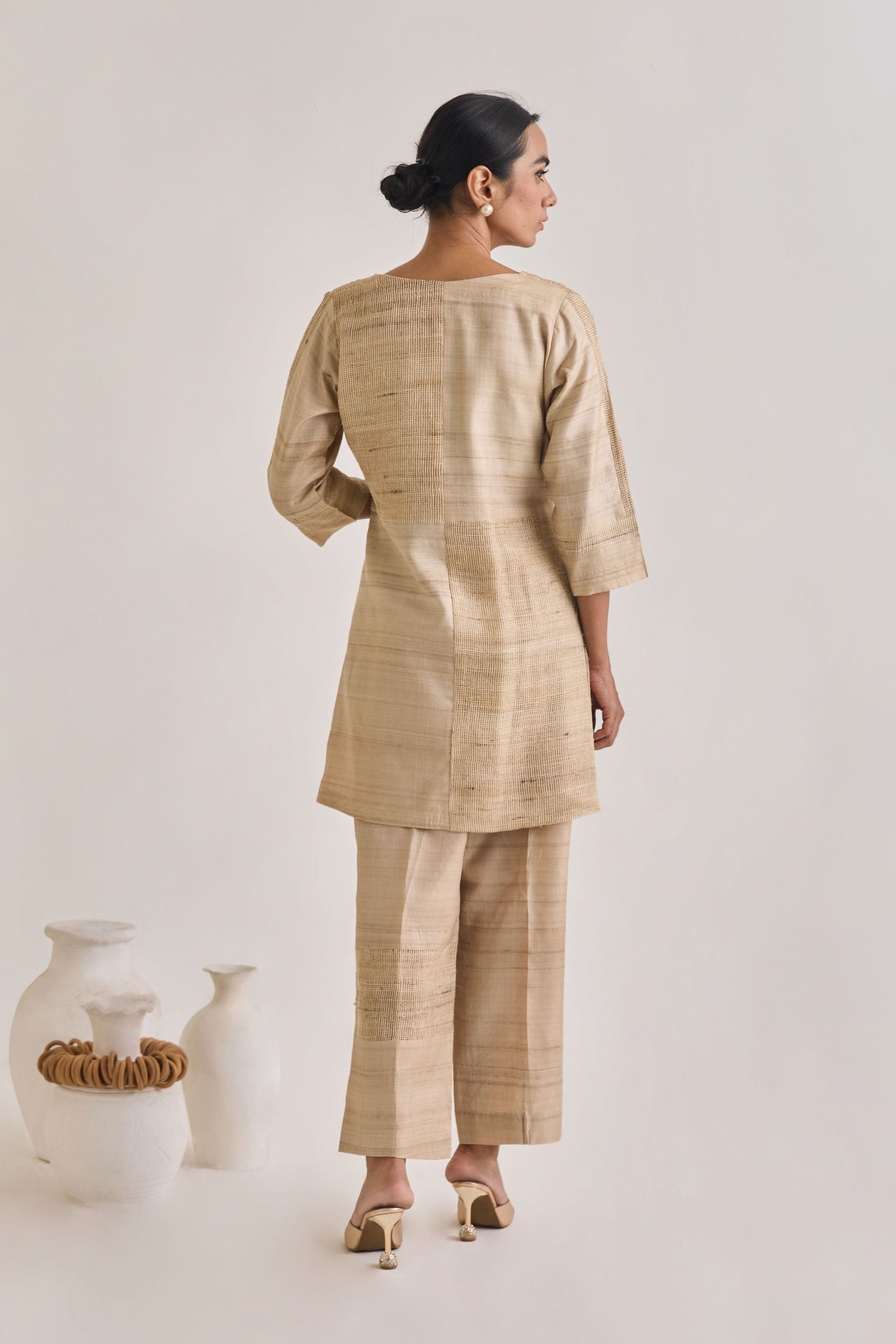 Back view of co-ord set with straight pants having a blocked panel design made out of Hathkarga fabric and kora raw tussar and has elbow length sleeves