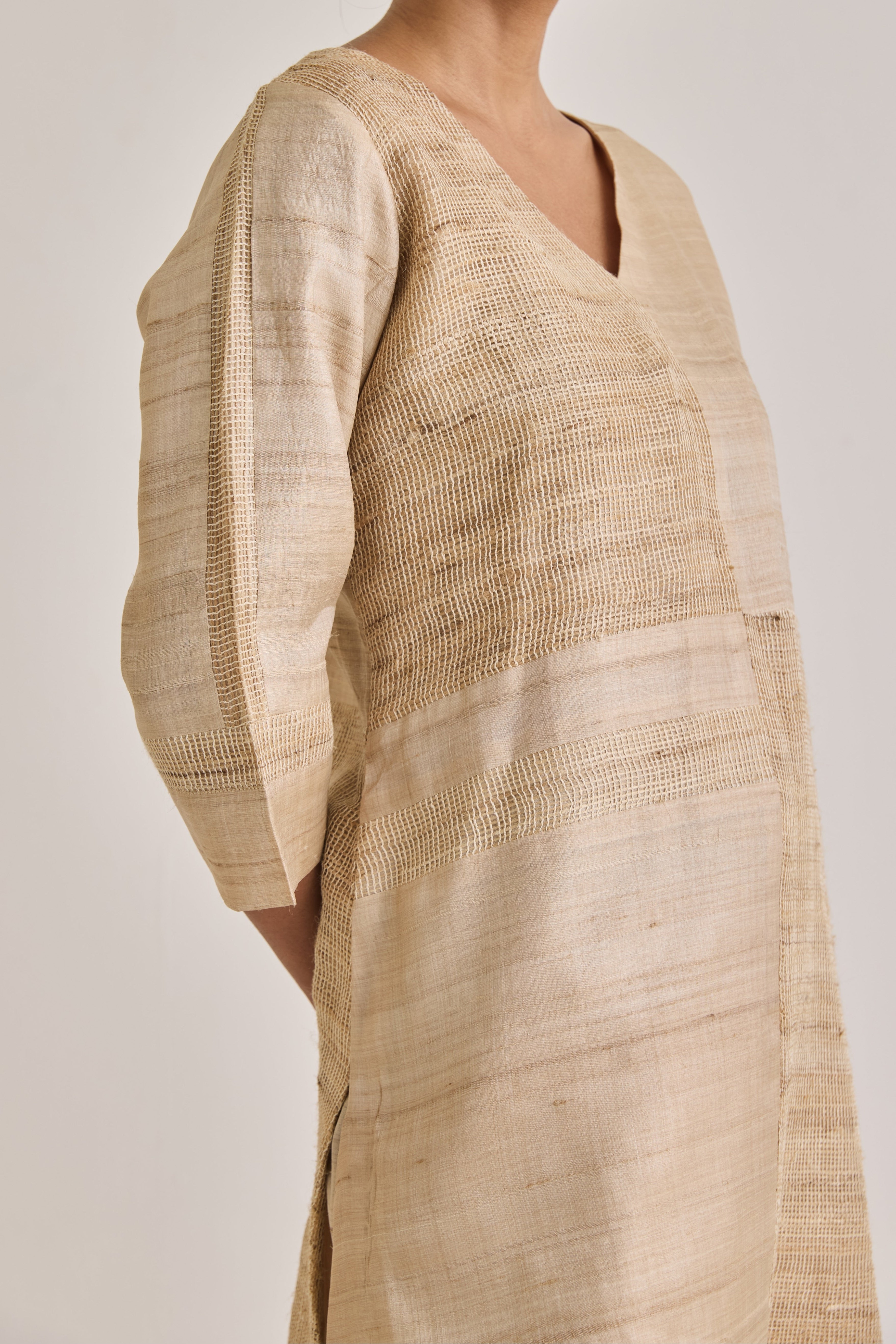Close up view of co-ord set with a V-neckline having a blocked panel design made out of Hathkarga fabric and kora raw tussar
