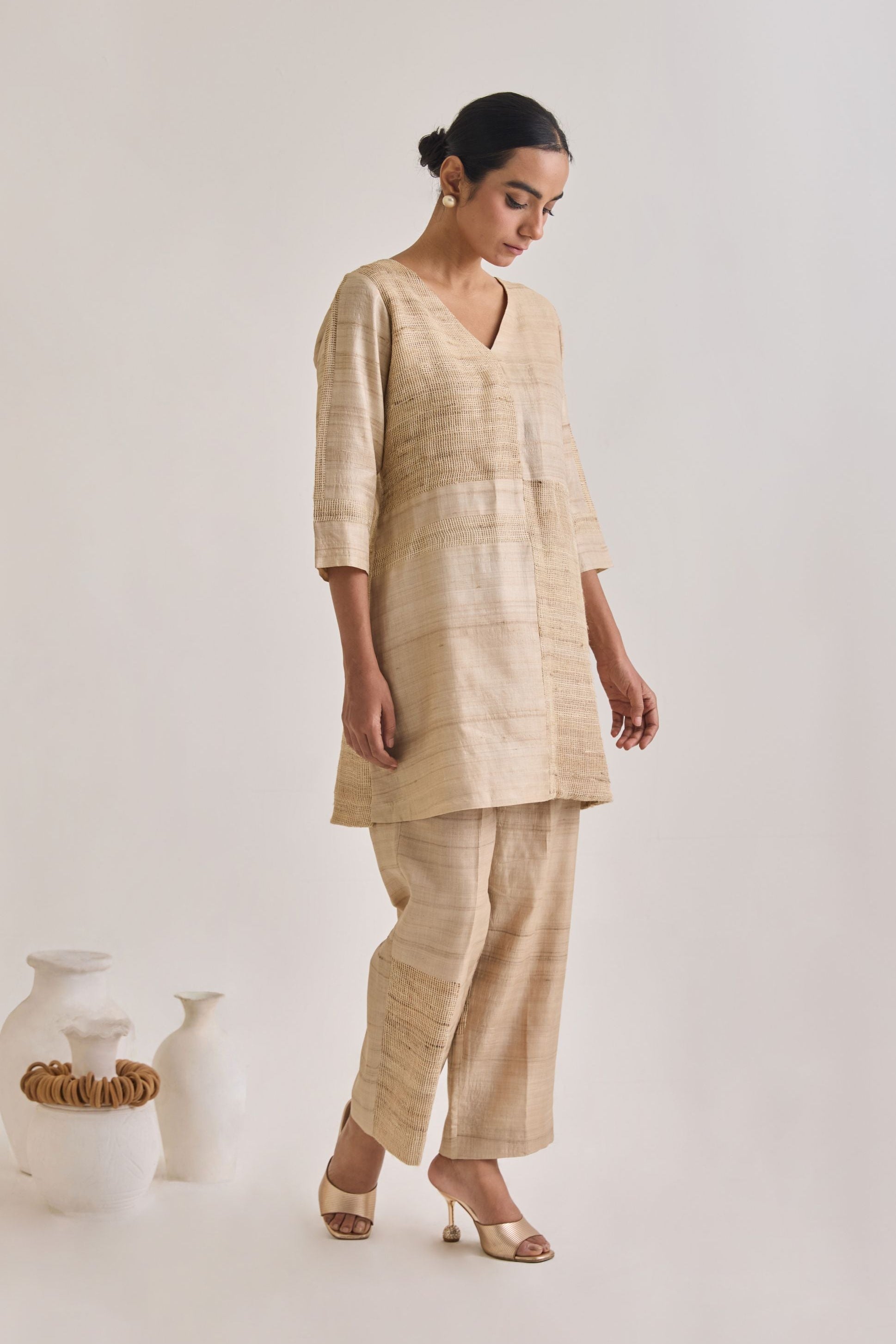 Side view of co-ord set with a V-neckline and straight pants having a blocked panel design made out of Hathkarga fabric and kora raw tussar and has elbow length sleeves