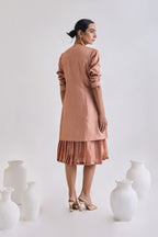Back view of Tussar sleeveless pleated dress with Full sleeve tussar coat with full sleeve rolled up to elbow 