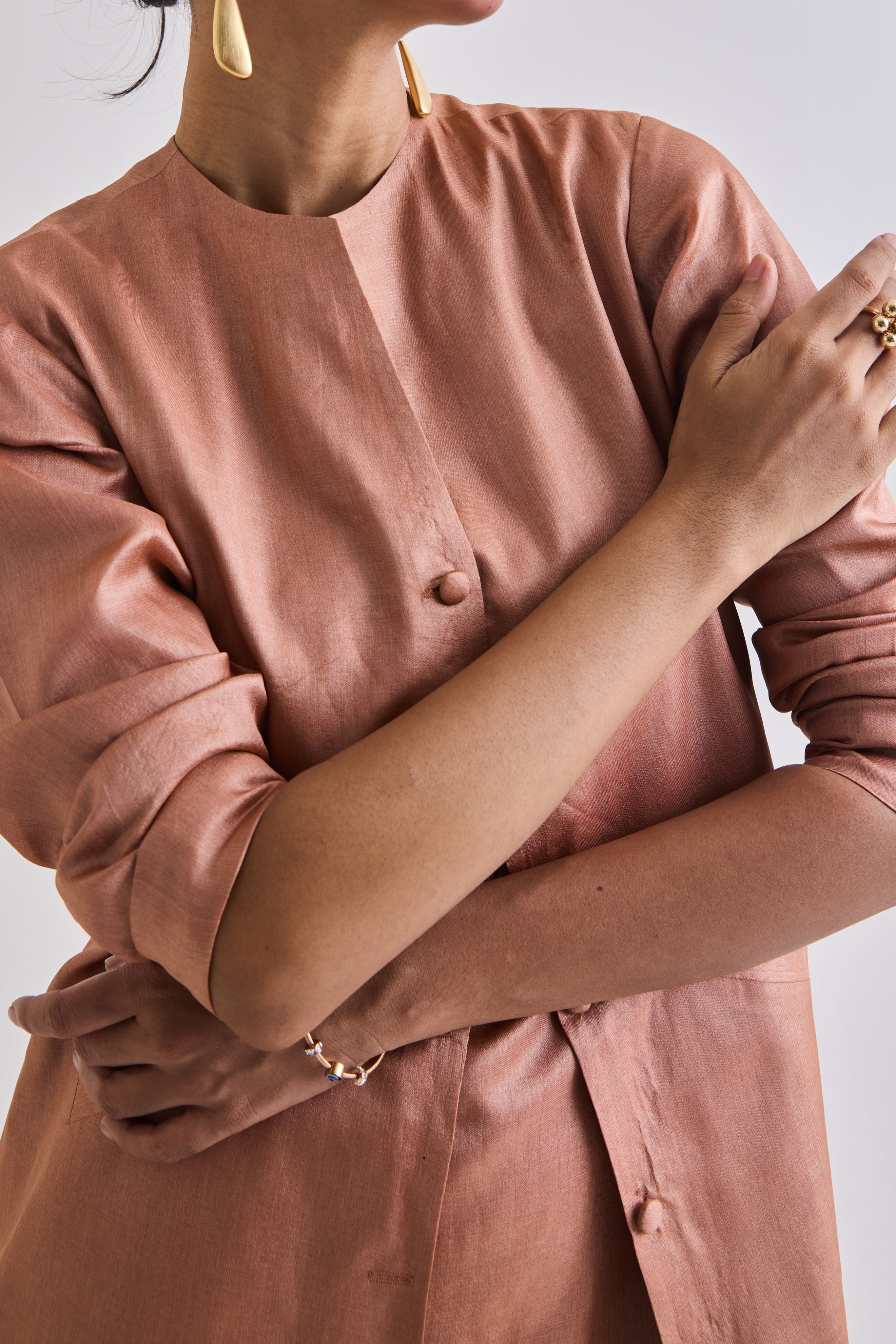 Detailed close up of Tussar coat with slant pockets and full sleeve rolled up to elbow