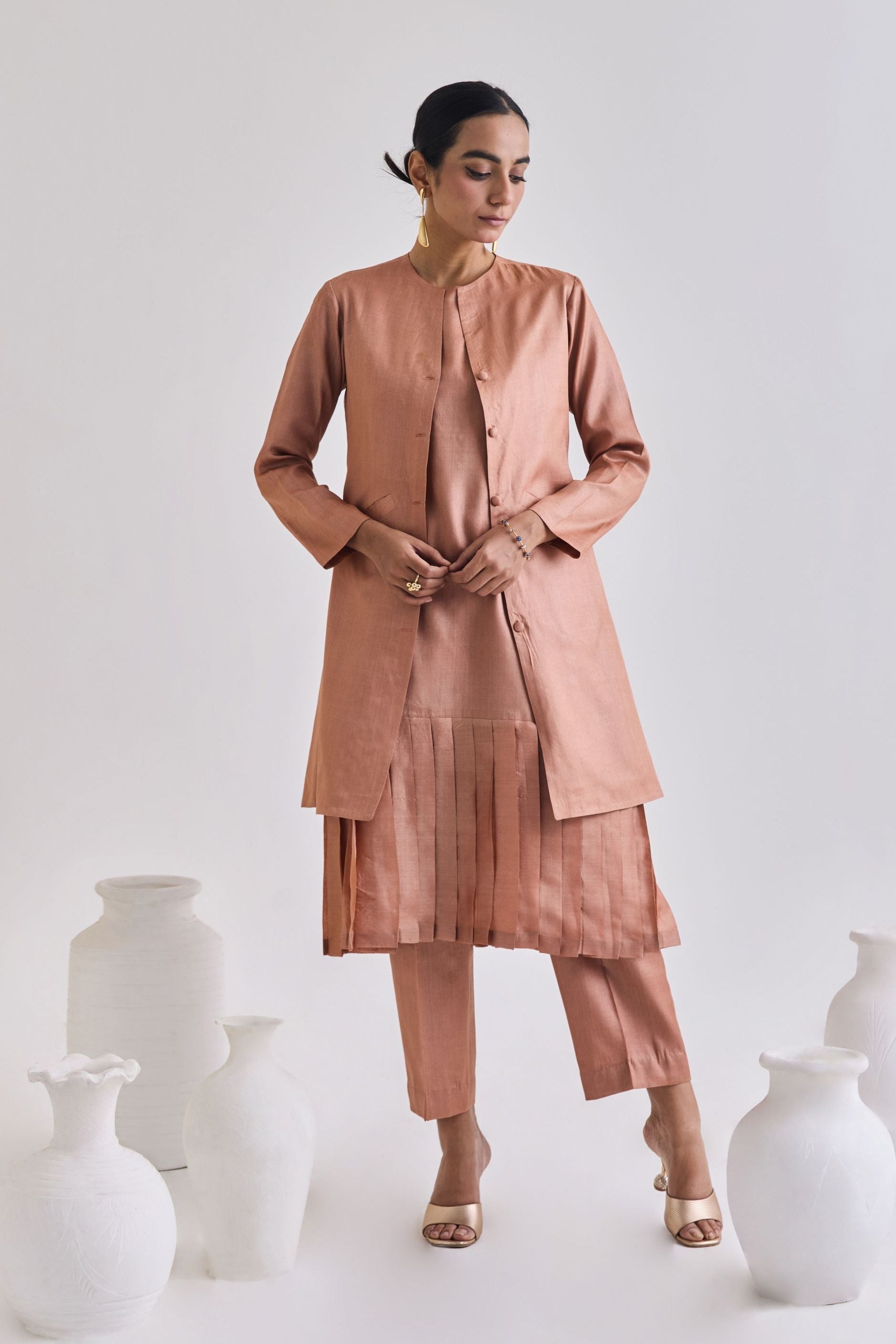Front view of Pure tussar set with a pleated sleeveless dress, a coat which has long sleeves and a pair of tailored pants