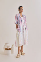 Front profile of a white cotton dress with weaved multicolour design and a blazer with elbow length sleeves with pink and blue stripes woven to the fabric