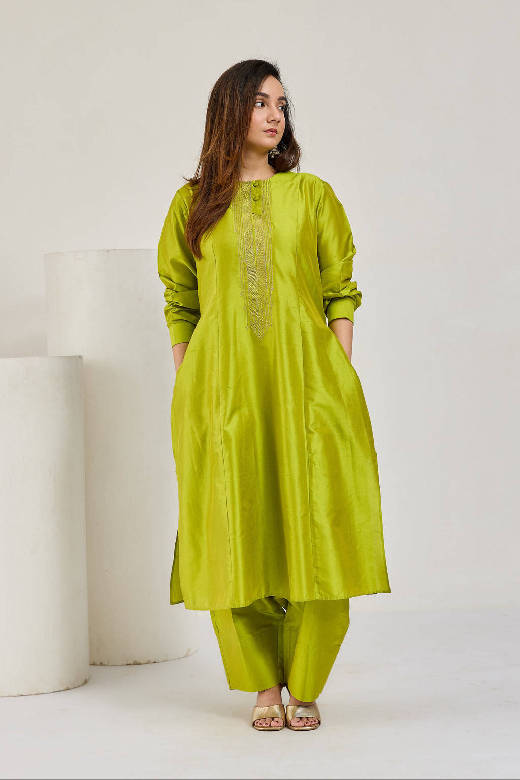 Model in lime green Katan silk kurta with full sleeves and barrel cocoon pants, without dupatta, looking to the right