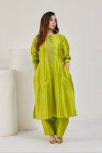Model in lime green Katan silk kurta with full sleeves and barrel cocoon pants, without dupatta, looking to the right